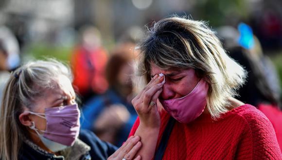 Una mujer llora afuera de la Casa Rosada durante la “Marcha de las Piedras” en homenaje a las víctimas del coronavirus, el 16 de agosto de 2021 en Buenos Aires, Argentina. (RONALDO SCHEMIDT / AFP).