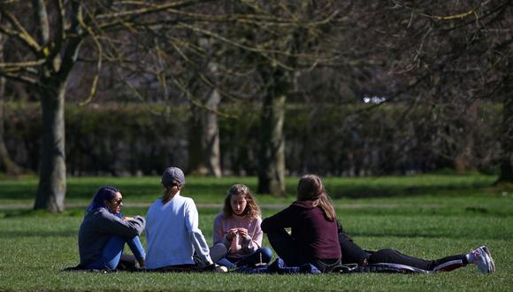 Un grupo de personas charla en Regent's Park en Londres, el 29 de marzo de 2021, mientras se alivian las restricciones por coronavirus Covid-19 de Inglaterra, lo que permite que grupos de hasta seis personas se reúnan afuera. (Foto de Hollie Adams / AFP).
