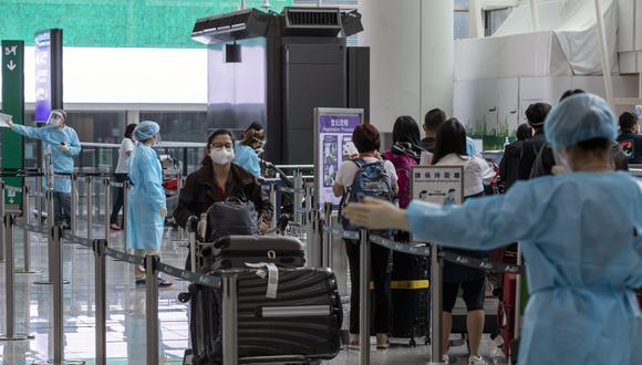 Foto referencial. Viajeros que se dirigen a la cuarentena en la sala de llegadas del Aeropuerto Internacional de Hong Kong en Hong Kong, China. (Paul Yeung/Bloomberg)
