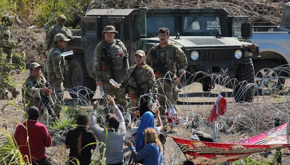 Migrantes son retenidos por La Guardia Nacional estadounidense al cruzar el Río Bravo para intentar ingresar a Estados Unidos, en Matamoros, México, el 25 de septiembre de 2023. (Foto de Abrahan Pineda-Jacome / EFE)