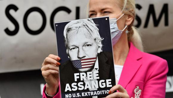 Una manifestante sostiene un cartel en apoyo al fundador de Wikileaks, Julian Assange, mientras protesta frente a los Tribunales Reales de Justicia en Londres. (JUSTIN TALLIS / AFP).