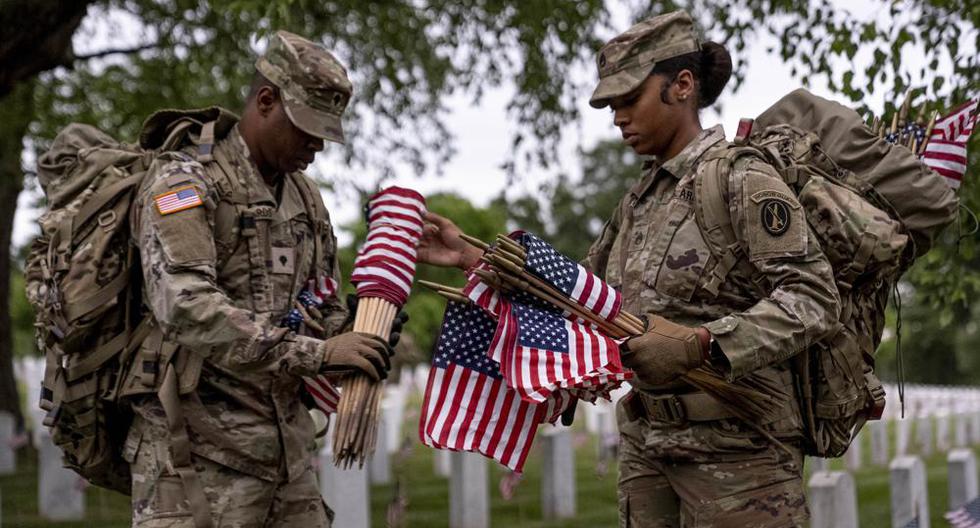 Los miembros del Tercer Regimiento de Infantería de Estados Unidos, también conocido como The Old Guard, colocan banderas frente a cada lápida para Banderas en el Cementerio Nacional de Arlington, el 25 de mayo de 2023. (Foto AP/Andrew Harnik).