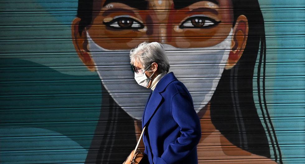 Una mujer que usa mascarilla como medida preventiva contra el coronavirus covid-19 pasa junto a un mural en Madrid, España, el 24 de febrero de 2021. (GABRIEL BOUYS / AFP).