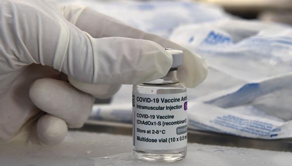 Un trabajador de la salud se prepara para sostener un vial de la vacuna del coronavirus de Oxford/AstraZeneca, el 7 de junio de 2021. (RYAD KRAMDI / AFP).