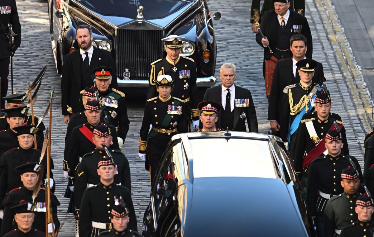 El rey Carlos III de Gran Bretaña, flanqueado por la princesa Ana, el príncipe Andrés (entre los carros y vestido de civil) y el príncipe Eduardo caminan detrás de la procesión del ataúd de la reina Isabel II. (OLI SCARFF / AFP).