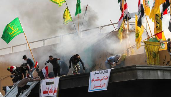 Las tropas de Estados Unidos disparan gases lacrimógenos contra manifestantes que protestan ante su embajada en Bagdad. (REUTERS/Thaier al-Sudani).