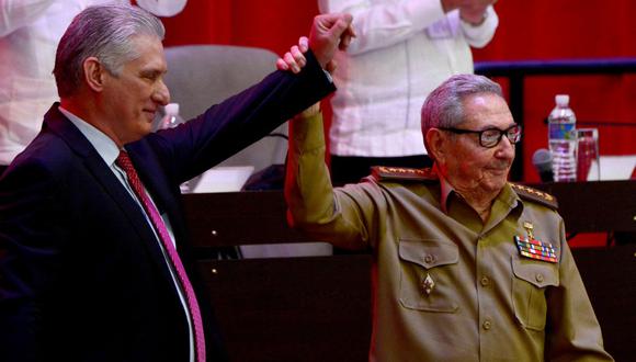 El primer secretario saliente del Partido Comunista de Cuba, Raúl Castro, levanta la mano del presidente Miguel Díaz-Canel. (Foto: AFP).