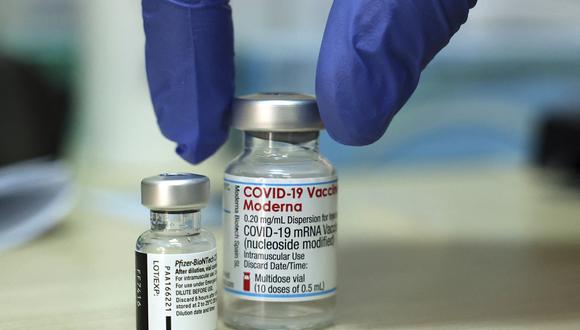 A medic places two vials of COVID-19 coronavirus vaccines (L to R): Pfizer-BioNTech and Moderna, on a table before administering doses at a Clalit Health Services Medical Centre in east Jerusalem on August 10, 2021. (Photo by HAZEM BADER / AFP)