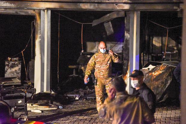 La policía y los bomberos inspeccionan el lugar del incendio. (ARBNORA MEMETI / AFP).