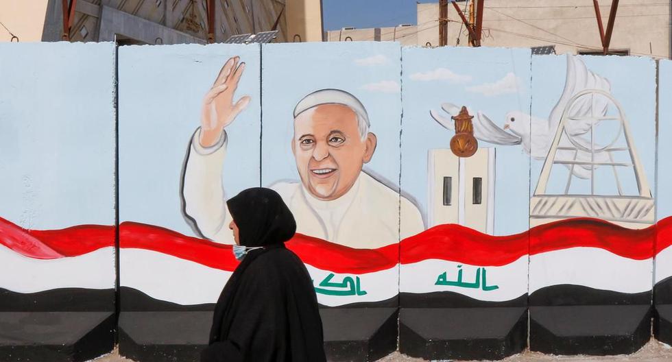 Una mujer pasa frente a un mural pintando en honor del papa Francisco en una iglesia de Bagdad antes de su visita a Irak. (Foto: Reuters)