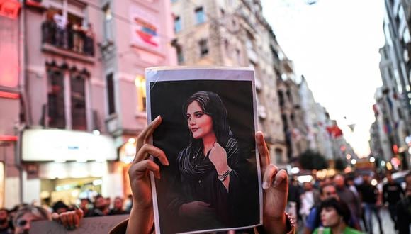 Una persona sostiene un retrato de Mahsa Amini durante una manifestación en apoyo a la joven iraní que murió después de ser arrestada en Teherán por la policía de moralidad de la República Islámica. (Foto: Ozan KOSE / AFP)