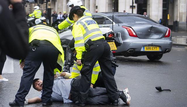 Fotografía de la policía deteniendo a un hombre que corría hacia el vehículo de Boris Johnson en Londres. (Victoria Jones/PA/AP).