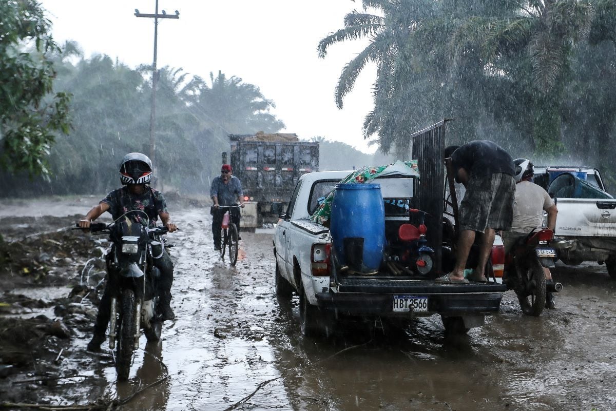 Residents leave their house in torrential rain in the old banana fields of El Progreso municipality, Yoro department, Honduras.  (WENDELL ESCOTO / AFP).