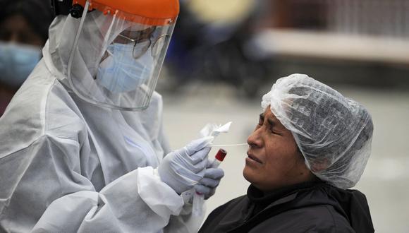 A Bolivian health personnel is seen taking a PCR test to detect COVID-19, outside Hospital de Clinicas in La Paz, on January 4, 2021. - Bolivia started the first 2021 weekend with 606 new COVID-19 cases, while many hospitals and medical centers are starting to get saturated due to the new outbreak in the country. (Photo by JORGE BERNAL / AFP)