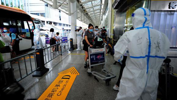 Los turistas pasan por los trámites previos a la salida en el aeropuerto de Sanya Phoenix, en la isla de Hainan, China, el 9 de agosto de 2022. (AFP).