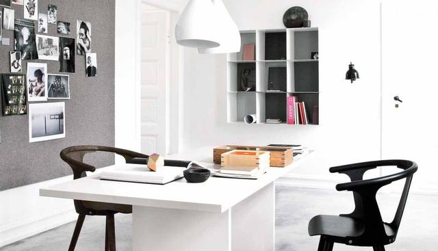 La mesa de líneas limpias se mimetiza con el tono blanco de la pared. La acompañan las sillas SK1, del danés Sami Kallio. La casa juega con tonos blancos y grises. (Foto: Norm Architects)