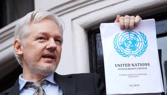 En esta foto de archivo tomada el 5 de febrero de 2016, el fundador de WikiLeaks, Julian Assange, se dirige a los medios de comunicación sosteniendo un informe impreso del fallo del Grupo de Trabajo de la ONU sobre Detención Arbitraria acerca de su caso desde el balcón de la embajada ecuatoriana en el centro de Londres. (NIKLAS HALLE'N / AFP).