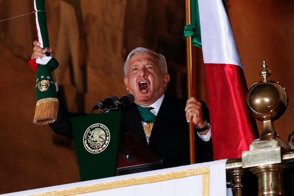 El presidente de México, Andrés Manuel López Obrador, sostiene la bandera nacional mientras realiza el "Grito de Independencia" en el Palacio Nacional en la Ciudad de México. (REUTERS/Henry Romero).