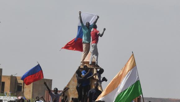 Los manifestantes ondean banderas de Níger y Rusia mientras se reúnen durante una manifestación en apoyo de la junta de Níger en Niamey el 30 de julio de 2023. (Foto por AFP)