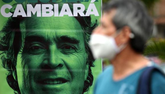 Una persona se para frente a una pancarta que del candidato presidencial colombiano por la Coalición Centro Esperanza Sergio Fajardo, durante un mitin de campaña en Cali, Colombia, el 18 de mayo de 2022. (Paola MAFLA / AFP).
