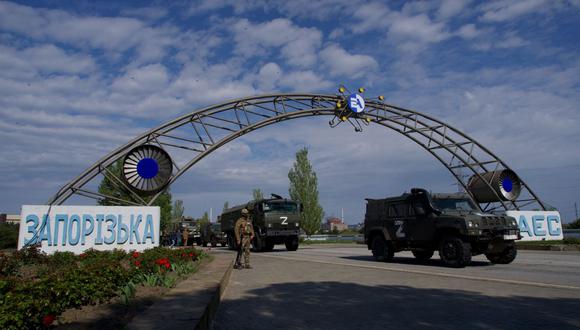 En esta foto de archivo tomada el 1 de mayo de 2022, vehículos militares rusos atraviesan las puertas de la central nuclear de Zaporizhzhia en Energodar. (Foto de Andrey BORODULIN / AFP)