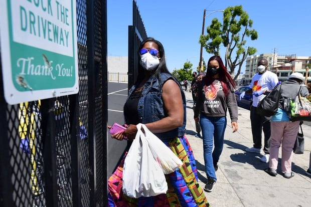 La gente ingresa a la Iglesia de Dios del Templo de la Calle 88 en Cristo para una distribución de alimentos de emergencia en Los Ángeles, California, durante la pandemia de coronavirus (Foto: Frederic J. Brown / AFP)