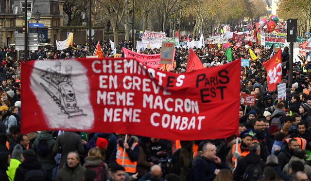 Personas sostienen pancartas y banderas durante una manifestación en las calles de París. (Foto: AFP)
