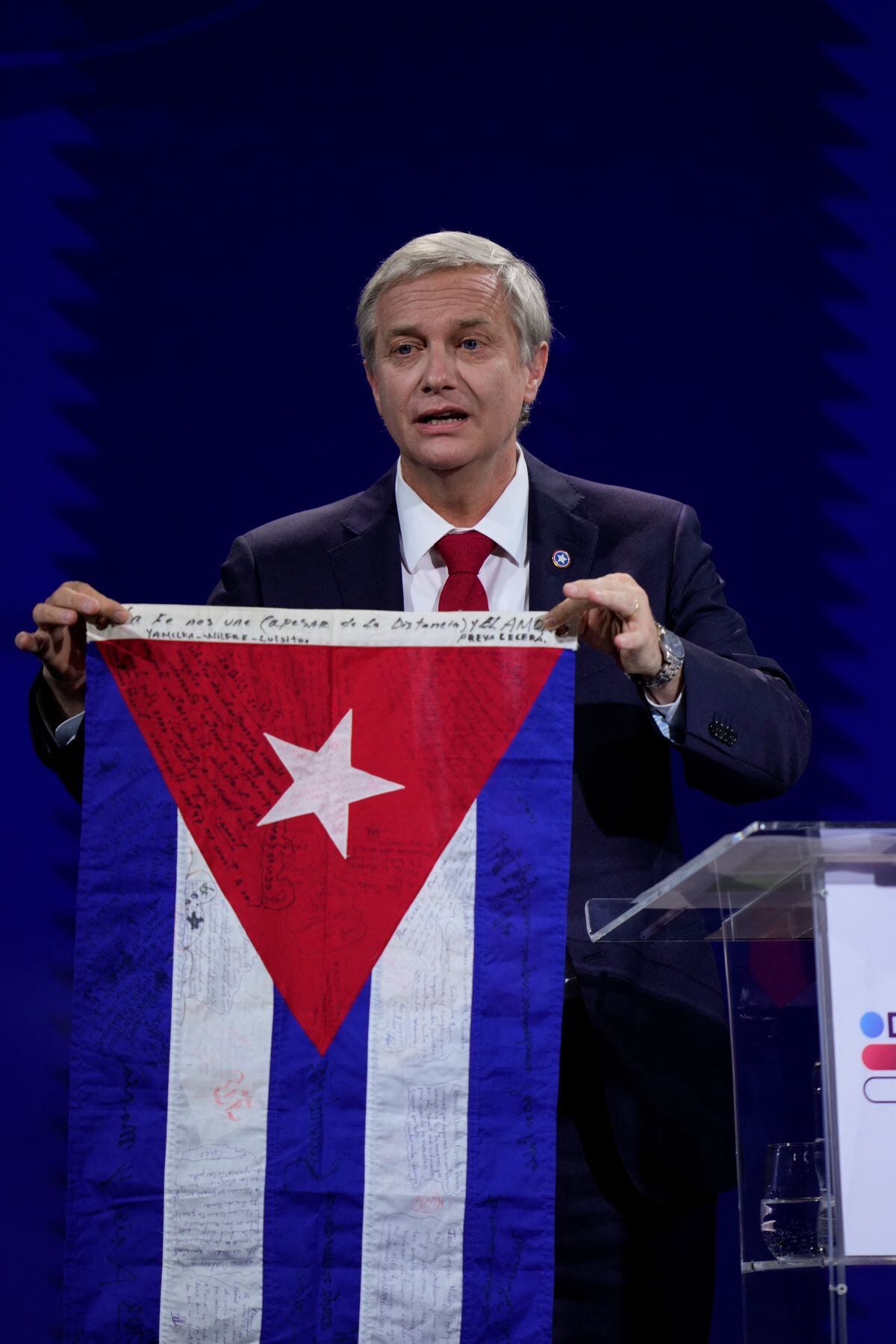 José Antonio Kast holds a Cuban flag before a televised debate on TVN in Santiago, on November 15, 2021. (ESTEBAN FELIX / POOL / AFP).