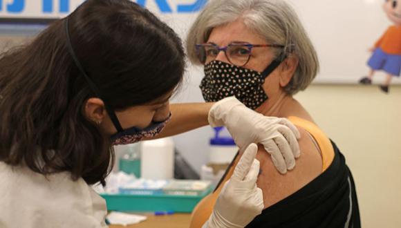 Una trabajadora de la salud israelí administra una tercera dosis de la vacuna Pfizer-BioNtech COVID-19 en Jerusalén el 1 de agosto de 2021. (Foto de Menahem KAHANA / AFP).