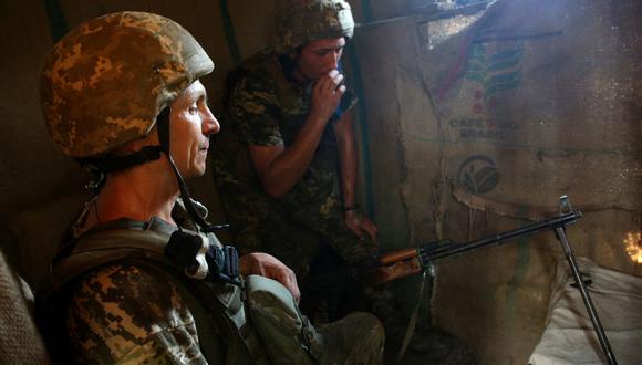 Los militares ucranianos descansan después de los enfrentamientos en la línea del frente con los separatistas respaldados por Rusia, cerca de la pequeña ciudad de Krasnogorivka, en la región de Donetsk, el 20 de julio de 2021. (Anatolii STEPANOV / AFP).