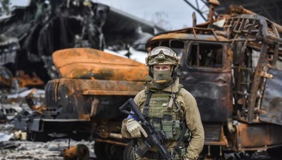 Un oficial de las fuerzas especiales ucranianas se encuentra cerca de un hangar dañado que contiene los restos del avión más grande del mundo, el carguero ucraniano Antonov An-225 Mriya 'Dream', en el aeródromo de Gostomel cerca de Kiev, Ucrania.