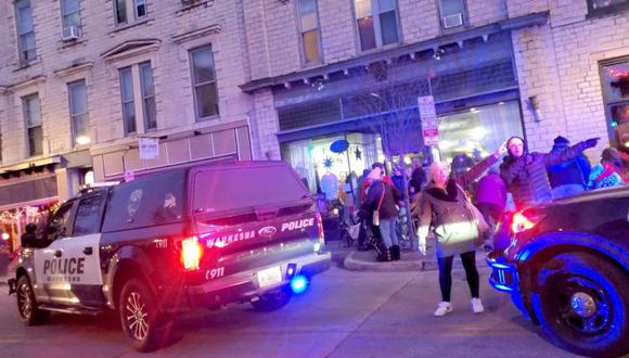 Las personas gesticulan mientras hablan con un oficial de policía después de que un automóvil atravesó a la multitud en un desfile navideño en Waukesha, Wisconsin, EE.UU., en esta imagen fija obtenida de un video de redes sociales. (Foto: Jordan Woynilko / Folleto vía REUTERS).