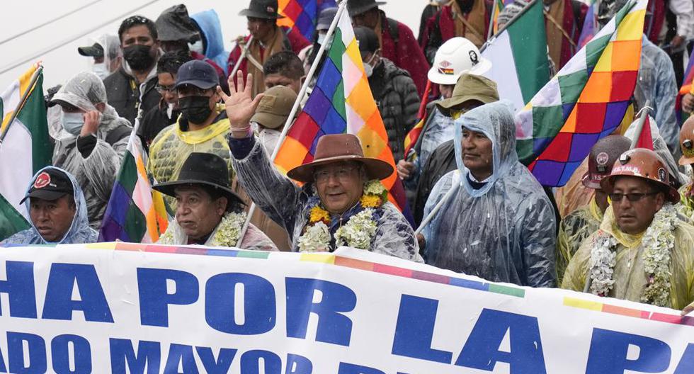 El presidente de Bolivia, Luis Arce (centro), saluda mientras camina con su vicepresidente David Choquehuanca, segundo a la izquierda, y con el expresidente Evo Morales, segundo a la derecha, durante una marcha en La Paz. (AP Foto / Juan Karita).