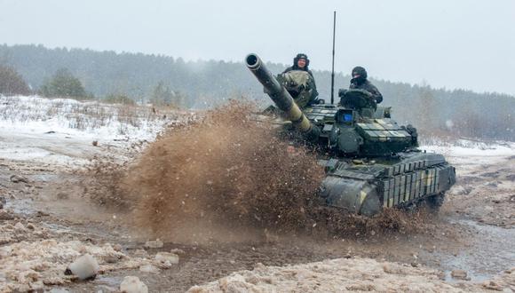 Los militares de las Fuerzas Militares de Ucrania de desplazan en un tanque durante los ejercicios con fuego real cerca de la ciudad de Chuguev, región de Kharkiv, el 10 de febrero de 2022. (Sergey BOBOK / AFP).
