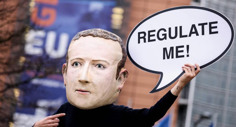 Un activista disfrazado con una máscara del confundador de Facebook, Mark Zuckerberg, porta un cartel en el que se puede leer: "¡Regúlenme!", frente al edificio de la Comisión Europea, en Bruselas, en diciembre del 2020. El actual escándalo del gigante tecnológico ha reavivado en Estados Unidos el debate sobre si estas plataformas deberían someterse a una regulación especial por parte de los gobiernos. (Foto: Kenzo Tribouillard / AFP / Archivo)