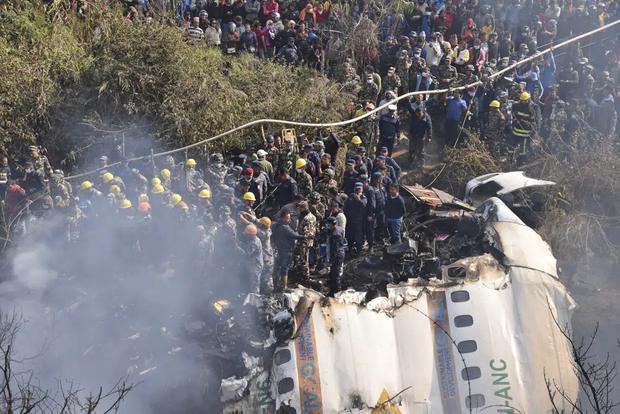 Rescue workers and Nepali civilians gather around the wreckage of a passenger plane that crashed in Pokhara, Sunday, January 15, 2023.  (AP Photo/Krishna Mani Paral)