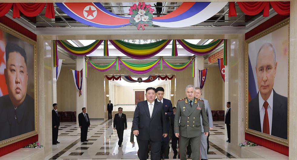 Esta foto del 27 de julio del 2022 muestra al líder de Corea del Norte, Kim Jong-un (izq.), guiando al ministro de Defensa de Rusia, Sergei Shoigu (der.), a la sala de banquetes durante su visita a la sede del Comité Central del Partido de los Trabajadores de Corea en Pyongyang. (Foto: AFP)