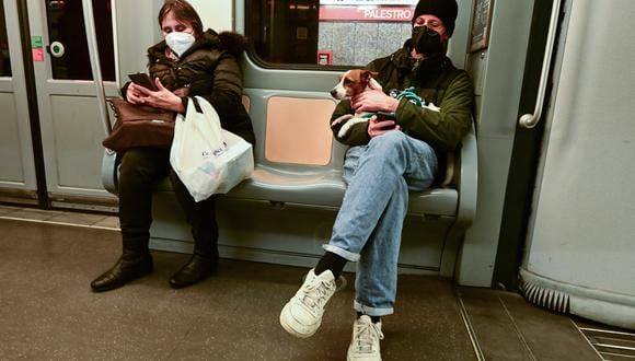Viajeros con máscaras protectoras se sientan en una de las líneas de metro de Milán el 4 de enero de 2022. (Foto: Miguel MEDINA / AFP)