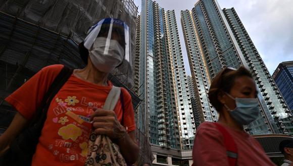 Los peatones pasan por el complejo de edificios residenciales Grand Central en Hong Kong el 28 de mayo de 2021, en medio de la pandemia de coronavirus. (Foto de Anthony WALLACE / AFP).