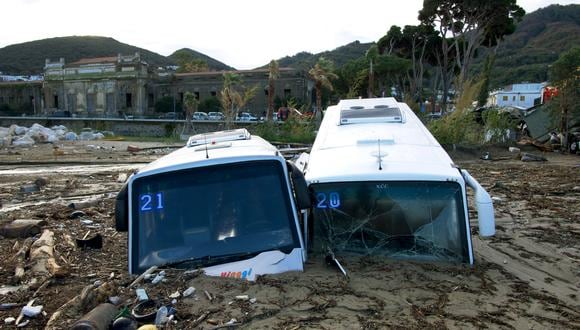 La imagen muestra unos autobuses turísticos dañados en el puerto de Casamicciola el 27 de noviembre de 2022, luego de fuertes lluvias que causaron un deslizamiento de tierra en la isla de Ischia, en el sur de Italia. (Foto por Eliano IMPERATO / AFP)