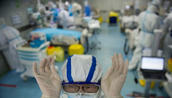 Esta foto tomada el 22 de febrero de 2020 muestra a una enfermera ajustando sus gafas en una unidad de cuidados intensivos que trata a pacientes con coronavirus en un hospital en Wuhan, en la provincia central de Hubei, China. (AFP / STR).