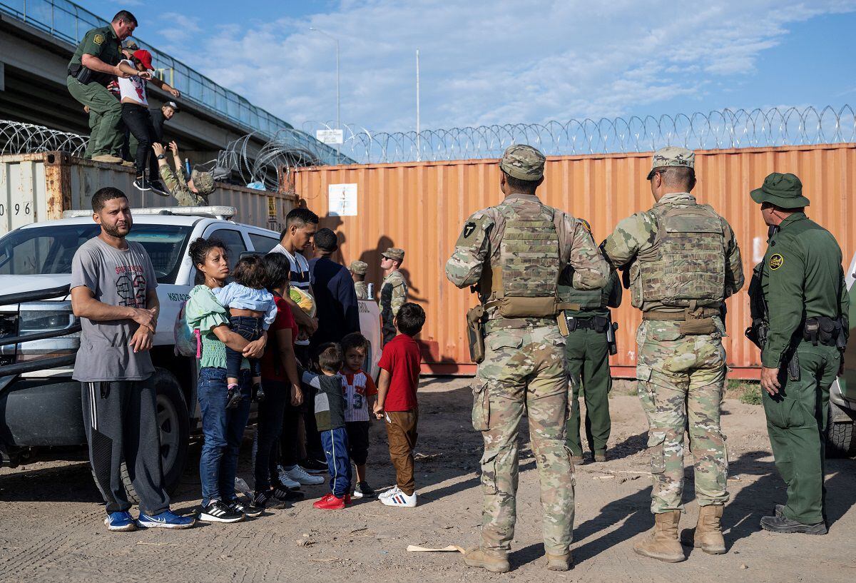 Venezuelans watch alongside other migrants in Eagle Pass, Texas, as they wait to be processed by U.S. Border Patrol agents on September 24, 2023. (Photo by ANDREW CABALLERO-REYNOLDS/AFP)