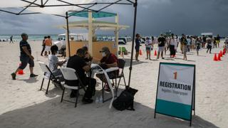 Turistas latinoamericanos se vacunan gratis contra el coronavirus en la playa de Miami Beach