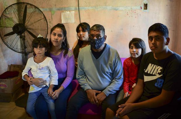 El sobreviviente de Covid-19 Raúl Almirón posa para una foto con sus hijos, en su casa de Florencio Varela, provincia de Buenos Aires. (Foto de RONALDO SCHEMIDT / AFP).