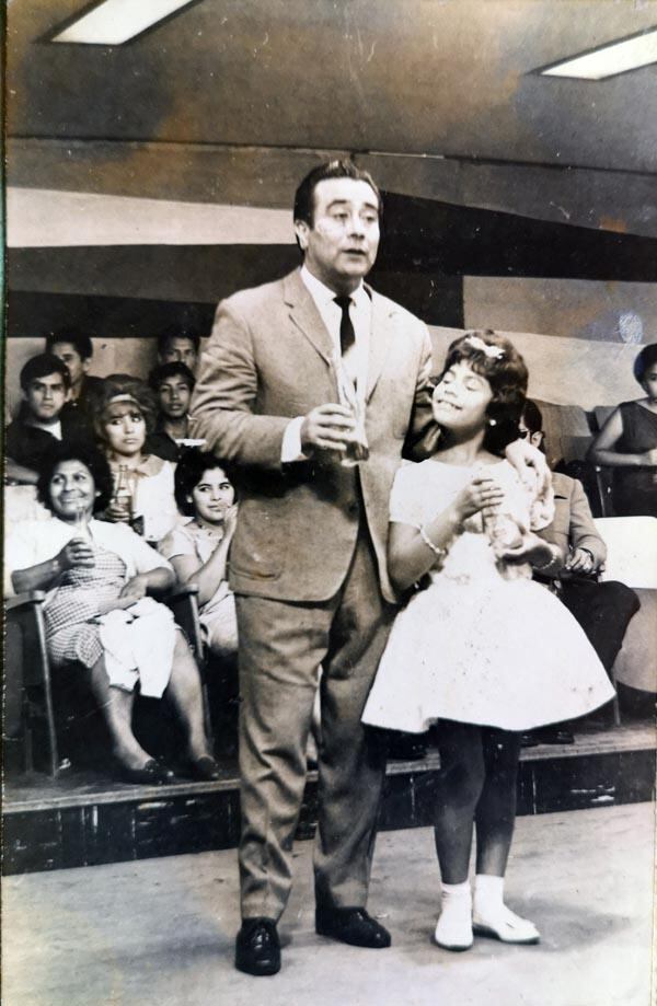 Como pequeña gran modelo de Gerardo Bessio, en el programa Capitán Adams. Tenía 11 años. Al fondo, a la izquierda con una botella en la mano, aparece su madre, doña Maruja. (Foto: Cortesía de la artista)