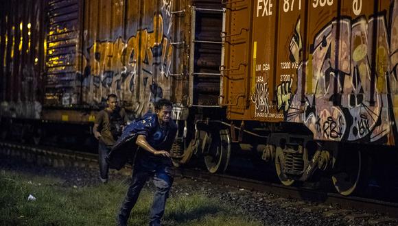 Migrantes sin documentos corre junto al tren conocido como "La Bestia", en la localidad de Las Patronas, Estado de Veracruz, el 9 de agosto de 2018. (Foto referencial de RONALDO SCHEMIDT / AFP)