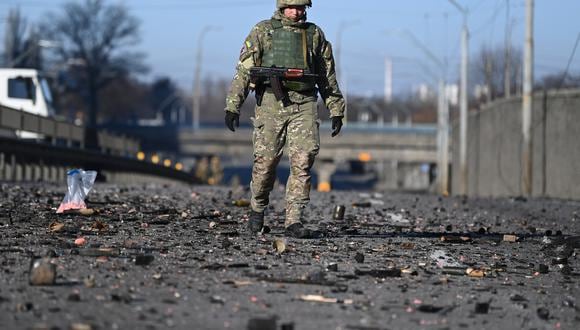 Un soldado ucraniano camina entre los escombros en el lado oeste de la capital ucraniana de Kiev el 26 de febrero de 2022. (Foto: Daniel LEAL / AFP).