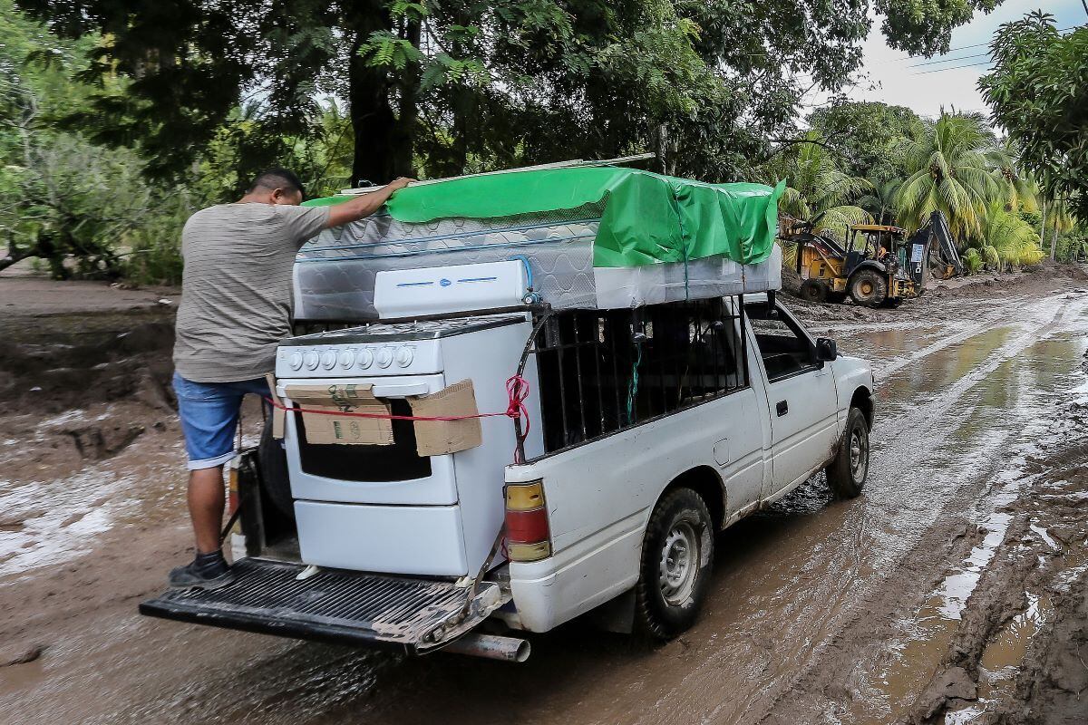 Residents leave their house with their belongings El Progreso, Yoro department, Honduras, before the arrival of Hurricane Julia.  (WENDELL ESCOTO / AFP).