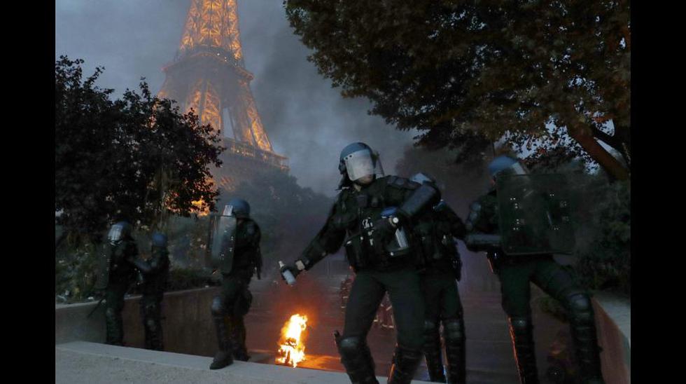 Polic&iacute;as de Francia lanzan bombas lacrim&oacute;genas cerca a la Torre Eiffel, mientras estos responden con bombas molotov.        REUTERS/Philippe Wojazer