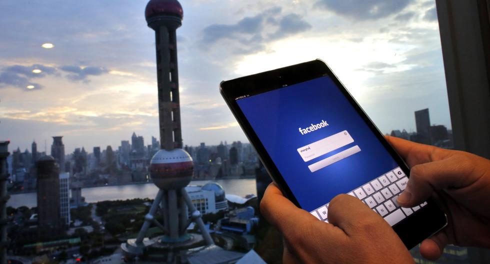 Imagen referencial. Un hombre sostiene un iPad con una aplicación de Facebook en un edificio del distrito financiero de Pudong en Shanghái. (REUTERS/Carlos Barria).